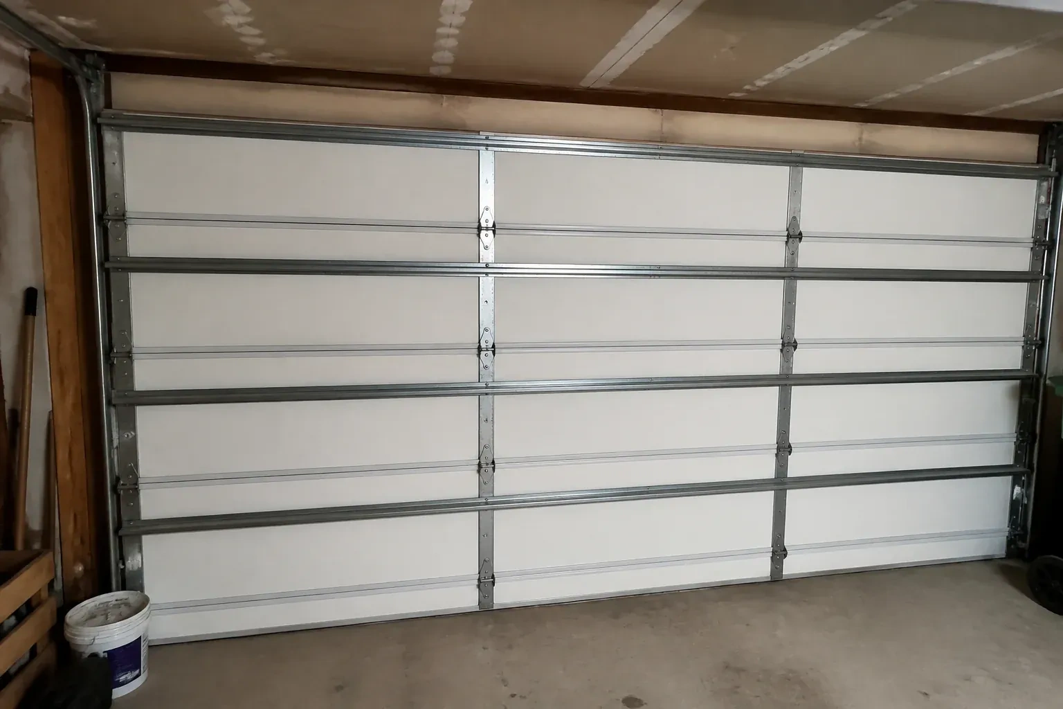 Interior of a closed sectional door with horizontal metal reinforcement struts. — Wind-Rated Garage Door Replacement, Oakville